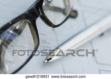 Stock Image - Close-up of ballpoint pen with a pair of eyeglasses on a form. Fotosearch