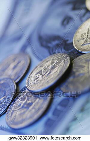 Stock Image - Close-up of coins on paper currency notes. Fotosearch