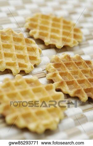 Stock Image - Close-up of four biscuits on a mat. Fotosearch