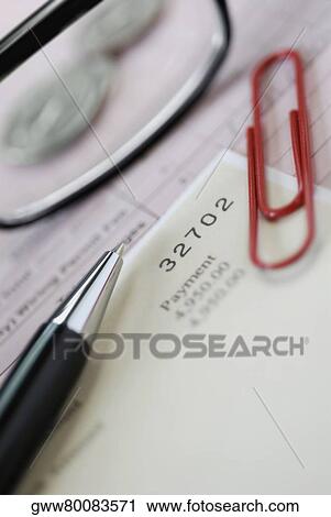 Stock Image - Close-up of pen and a paper clip on documents. Fotosearch