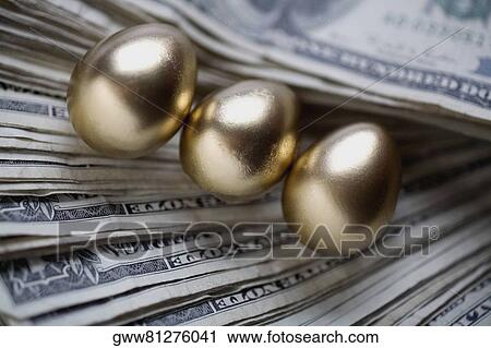 Stock Image - Golden eggs on US paper currency. Fotosearch