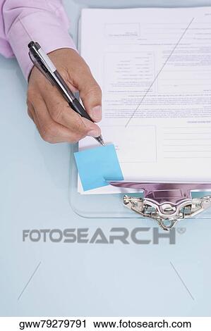 High angle view of a person's hand writing on a document View Large Photo Image Stock Image - High angle view of a person's hand writing on a document. Fotosearch