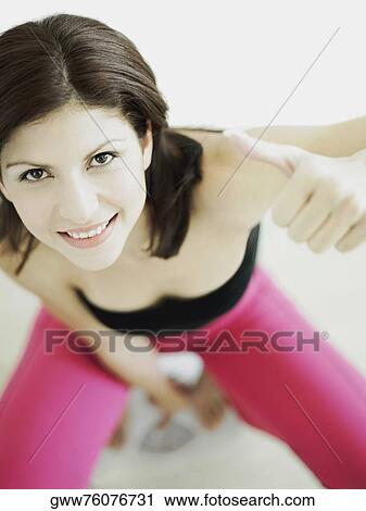 High angle view of a young woman on a weighing scale and showing thumbs up View Large Photo Image Stock Image - High angle view of a young woman on a weighing scale and showing thumbs up. Fotosearch
