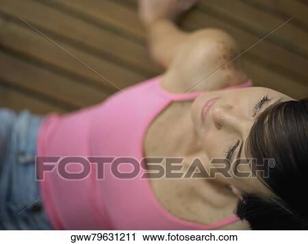 High angle view of a young woman sitting on the hardwood floor View Large Photo Image Stock Image - High angle view of a young woman sitting on the hardwood floor. Fotosearch