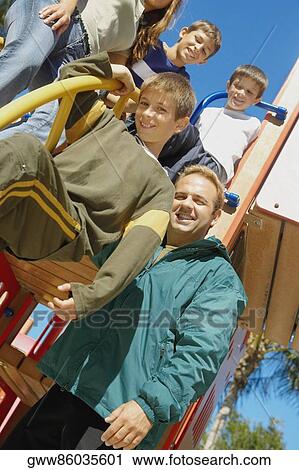 Low angle view of a family on a jungle gym View Large Photo Image Stock Image - Low angle view of a family on a jungle gym. Fotosearch