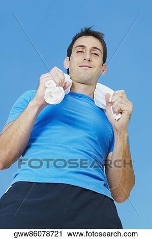 Low angle view of a mid adult man holding a towel around his neck View Large Photo Image Stock Image - Low angle view of a mid adult man holding a towel around his neck. Fotosearch
