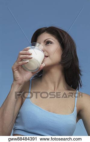Low angle view of a young woman drinking milk View Large Photo Image Stock Image - Low angle view of a young woman drinking milk. Fotosearch