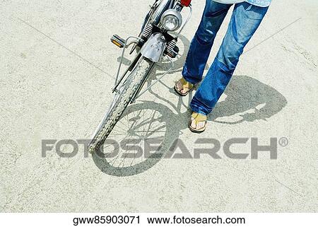 Low section view of a man with a bicycle View Large Photo Image Stock Image - Low section view of a man with a bicycle. Fotosearch