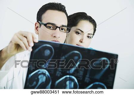 Male doctor and a female doctor examining an X-Ray View Large Photo Image Stock Image - Male doctor and a female doctor examining an X-Ray. Fotosearch