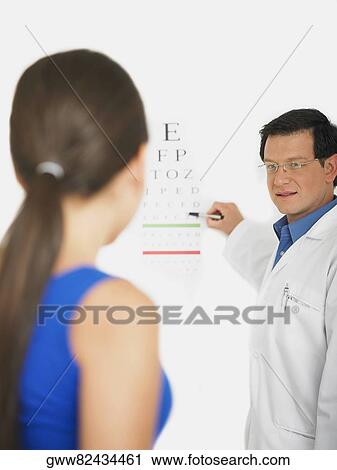 Male doctor doing an eye exam of a female patient View Large Photo Image Stock Image - Male doctor doing an eye exam of a female patient. Fotosearch