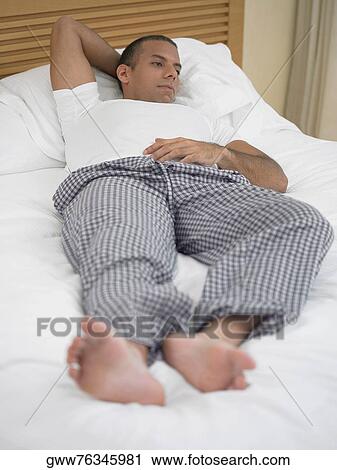 Mid adult man lying on the bed View Large Photo Image Stock Image - Mid adult man lying on the bed. Fotosearch