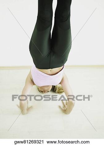 Stock Image - Mid adult woman in a yoga pose. Fotosearch