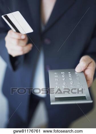 Mid section view of a businesswoman operating a calculator View Large Photo Image Stock Image - Mid section view of a businesswoman operating a calculator. Fotosearch