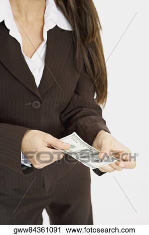 Mid section view of a businesswoman holding American paper currency View Large Photo Image Stock Image - Mid section view of a businesswoman holding American paper currency. Fotosearch