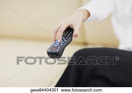 Mid section view of a person holding a remote control View Large Photo Image Stock Image - Mid section view of a person holding a remote control. Fotosearch