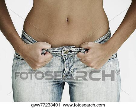 Mid section view of a woman holding a pair of jeans View Large Photo Image Stock Image - Mid section view of a woman holding a pair of jeans. Fotosearch