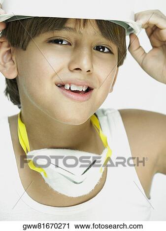 Stock Image - Portrait of a boy holding his hardhat. Fotosearch