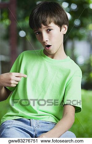Stock Image - Portrait of a boy pointing to himself. Fotosearch