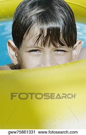 Portrait of a boy with an inflatable ring in a swimming pool View Large Photo Image Stock Image - Portrait of a boy with an inflatable ring in a swimming pool. Fotosearch