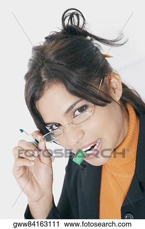 Stock Image - Portrait of a businesswoman adjusting her eyeglasses. Fotosearch