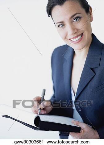 Portrait of a businesswoman smiling and writing on a file View Large Photo Image Stock Image - Portrait of a businesswoman smiling and writing on a file. Fotosearch
