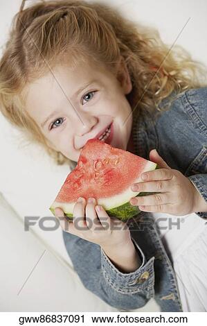 Portrait of a girl holding a slice of watermelon and smiling View Large Photo Image Stock Image - Portrait of a girl holding a slice of watermelon and smiling. Fotosearch