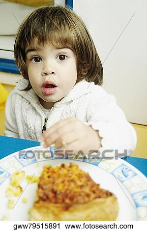 Portrait of a girl sitting at a table with a plate of cake in front of her View Large Photo Image Stock Image - Portrait of a girl sitting at a table with a plate of cake in front of her. Fotosearch