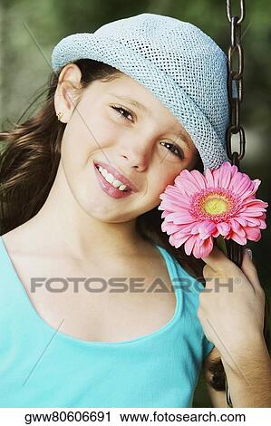 Portrait of a girl smiling on a chain swing ride with a flower View Large Photo Image Stock Image - Portrait of a girl smiling on a chain swing ride with a flower. Fotosearch