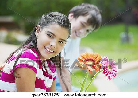 Portrait of a girl smiling with a boy sitting beside her View Large Photo Image Stock Image - Portrait of a girl smiling with a boy sitting beside her. Fotosearch