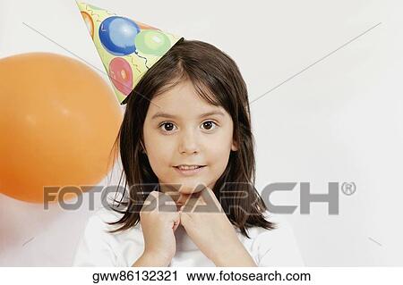 Portrait of a girl wearing a party hat and smiling View Large Photo Image Stock Image - Portrait of a girl wearing a party hat and smiling. Fotosearch