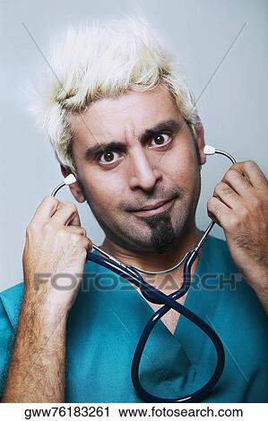 Stock Image - Portrait of a male doctor holding a stethoscope. Fotosearch