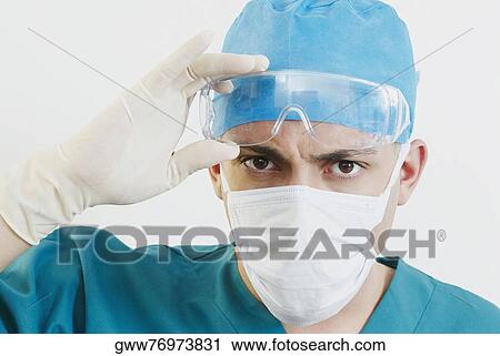 Portrait of a male doctor holding protective eyewear View Large Photo Image Stock Image - Portrait of a male doctor holding protective eyewear. Fotosearch