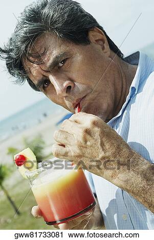 Stock Image - Portrait of a mature man drinking juice. Fotosearch