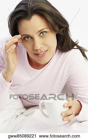 Portrait of a mature woman holding a coffee cup and smiling View Large Photo Image Stock Image - Portrait of a mature woman holding a coffee cup and smiling. Fotosearch