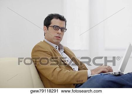 Portrait of a mid adult man using a laptop View Large Photo Image Stock Image - Portrait of a mid adult man using a laptop. Fotosearch