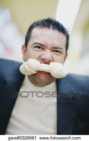 Portrait of a mid adult man with a dog bone in his mouth View Large Photo Image Stock Image - Portrait of a mid adult man with a dog bone in his mouth. Fotosearch