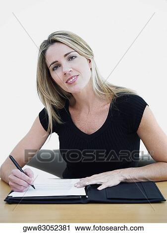 Portrait of a mid adult woman holding a pen on a file View Large Photo Image Stock Image - Portrait of a mid adult woman holding a pen on a file. Fotosearch