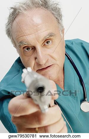 Portrait of a senior male doctor holding a handgun View Large Photo Image Stock Image - Portrait of a senior male doctor holding a handgun. Fotosearch