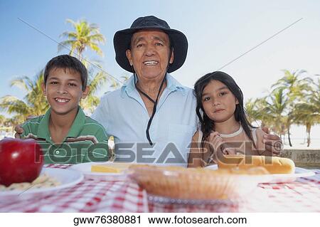 Portrait of a senior man and his grandchildren at the table View Large Photo Image Stock Image - Portrait of a senior man and his grandchildren at the table. Fotosearch