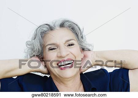 Portrait of a senior woman laughing with her hands behind her head View Large Photo Image Stock Image - Portrait of a senior woman laughing with her hands behind her head. Fotosearch