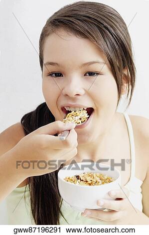 Portrait of a teenage girl eating a bowl of corn flakes View Large Photo Image Stock Image - Portrait of a teenage girl eating a bowl of corn flakes. Fotosearch