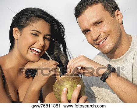 Portrait of a young couple holding a coconut View Large Photo Image Stock Image - Portrait of a young couple holding a coconut. Fotosearch