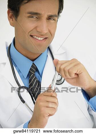 Portrait of a young male doctor holding a pen View Large Photo Image Stock Image - Portrait of a young male doctor holding a pen. Fotosearch