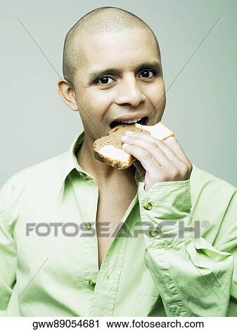 Portrait of a young man eating a slice of bread View Large Photo Image Stock Image - Portrait of a young man eating a slice of bread. Fotosearch