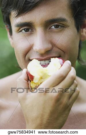 Portrait of a young man eating an apple View Large Photo Image Stock Image - Portrait of a young man eating an apple. Fotosearch