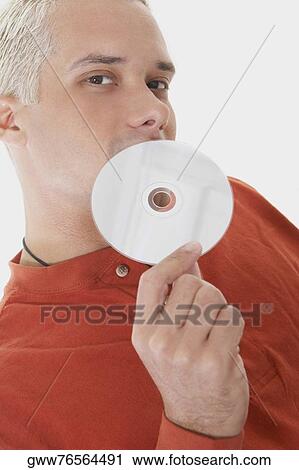 Stock Image - Portrait of a young man holding a CD. Fotosearch