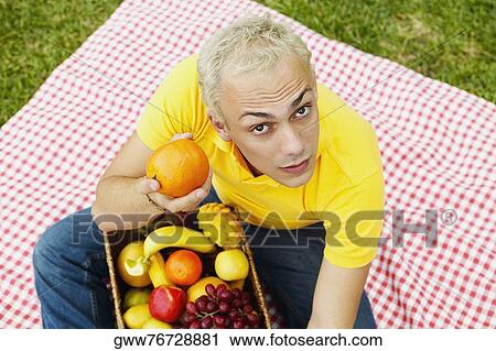 Portrait of a young man holding a basket of fruit View Large Photo Image Stock Image - Portrait of a young man holding a basket of fruit. Fotosearch