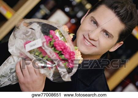 Portrait of a young man holding a bouquet of flowers View Large Photo Image Stock Image - Portrait of a young man holding a bouquet of flowers. Fotosearch