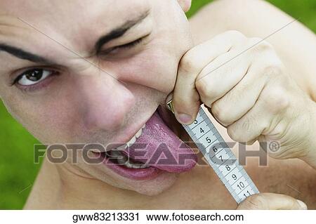 Portrait of a young man measuring his tongue View Large Photo Image Stock Image - Portrait of a young man measuring his tongue. Fotosearch