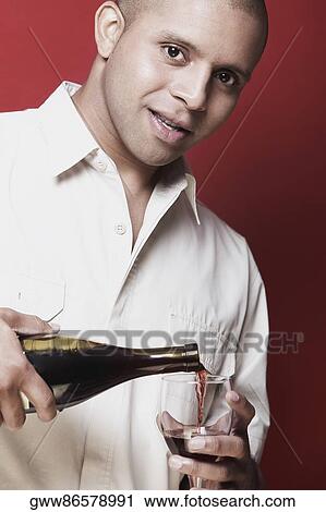 Portrait of a young man pouring red wine into a wine glass View Large Photo Image Stock Image - Portrait of a young man pouring red wine into a wine glass. Fotosearch